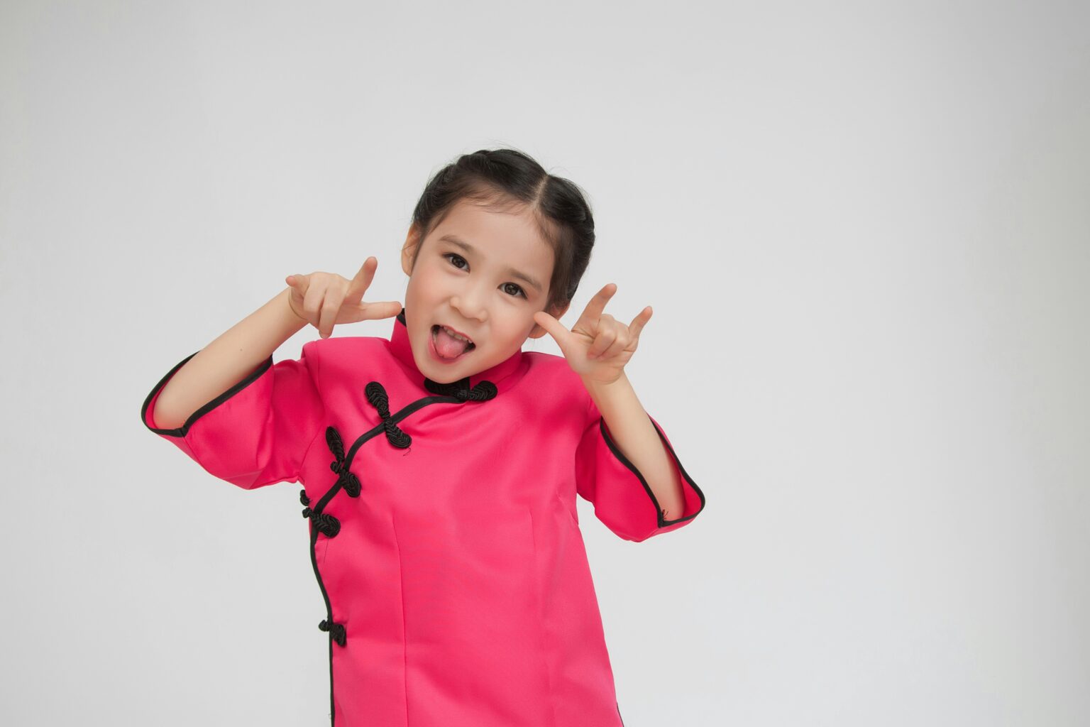 Young girl posing playfully in a bright pink outfit